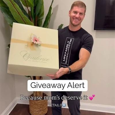 Dr. Brett Lukas holding a giftbox and smiling to advertise a giveway