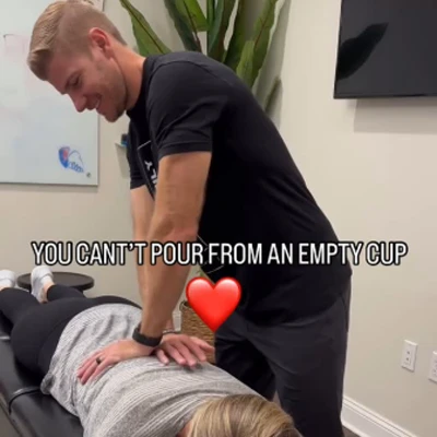 Dr Brett Lukas performing a back adjustment on a patient who is laying face down on an adjustment table