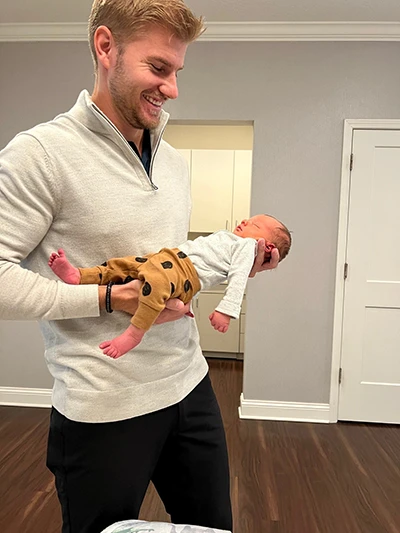 Chiropractor Ponte Vedra Beach FL Brett Lukas Holding Baby Dr. Brett Lukas holding a sleeping infant patient before an adjustment