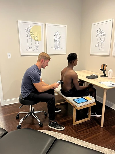 Chiropractor Ponte Vedra Beach FL Brett Lukas Scanning Patient Dr. Brett Lukas using the insight scanner on an adult patient to determine necessary steps in treatment